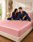 Couple complice assis sur un drap housse rose en soie de mûrier