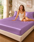 Femme souriante assise sur un drap housse violet en soie de mûrier