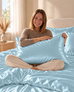 Femme assise sur son lit avec une taie d'oreiller bleue en soie de mûrier