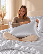 Femme assise sur son lit avec une taie d'oreiller gris argenté en soie de mûrier