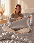Femme assise sur son lit avec une taie d'oreiller grise en soie de mûrier