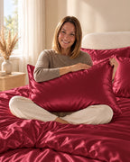 Femme assise sur son lit avec une taie d'oreiller rouge en soie de mûrier