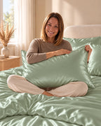Femme assise sur son lit avec une taie d'oreiller vert clair en soie de mûrier